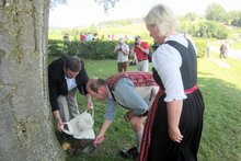 Fotos (von Wilhelm Frickh): Die Pfaffinger B&uuml;rgermeisterin Gabriele Aigenstuhler, der Frankenburger B&uuml;rgermeister Kons. Johann Baumann und W&uuml;rfelspiel-Obmann Anton Streicher beim &bdquo;Erdentausch&ldquo; am Haushamerfeld am Freitag, 19. Juni 2015